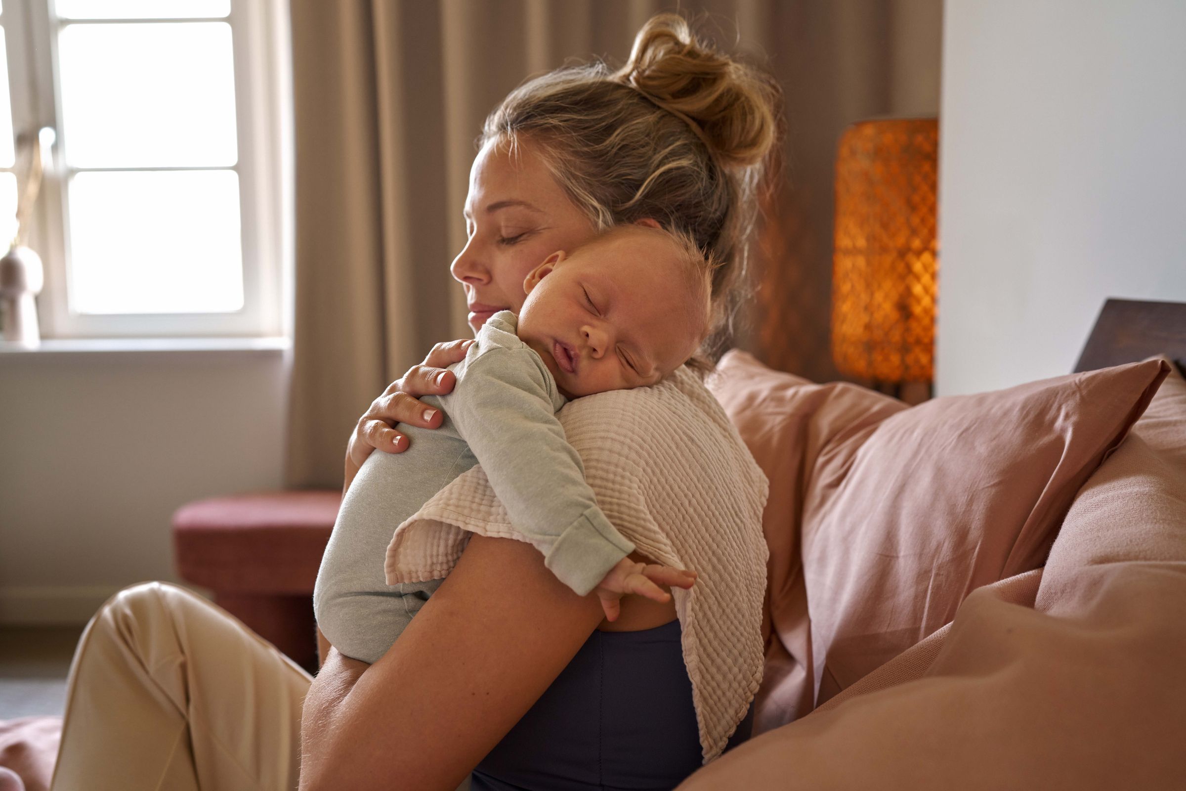 A mum holding her sleeping baby